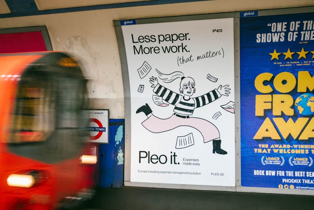 An advert for Pleo using 16-sheet advertising, across the track, on the London Underground. A tube car is blurred as it rushes past.
