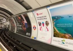 The platform of the London Underground station with 16-sheet adverts across the track.