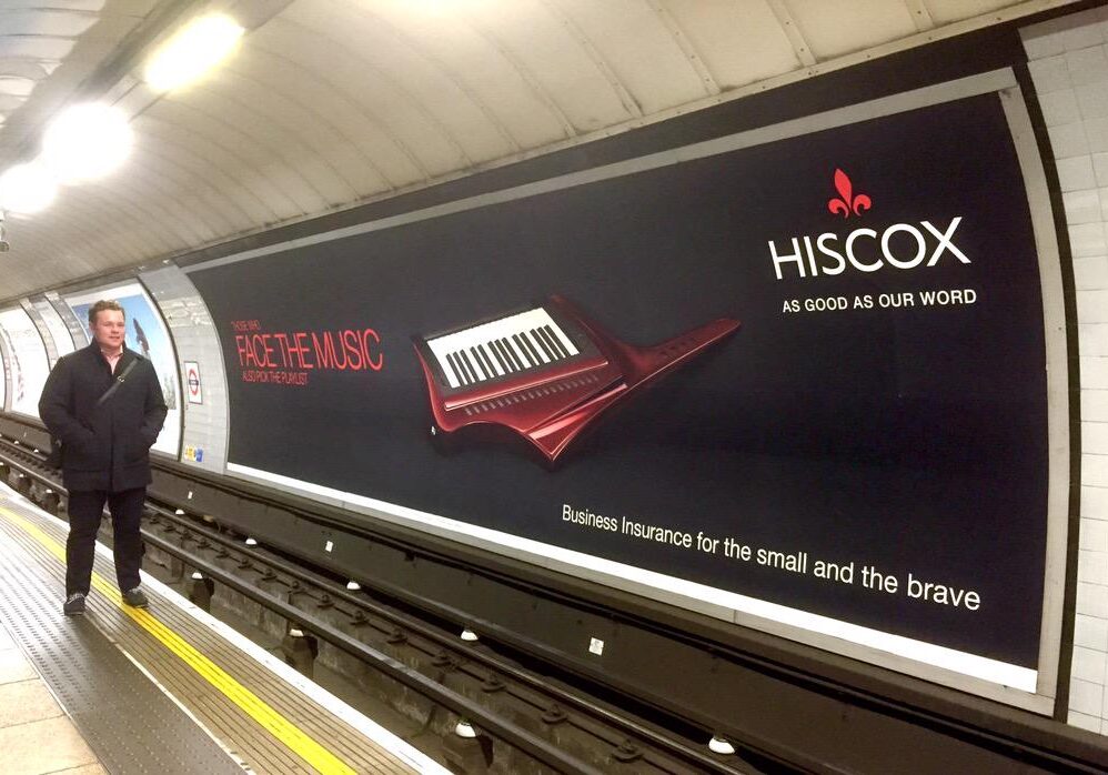 An advert for Hiscox appears across the track on the London Underground. This format is called a cross track paper 96-sheet.